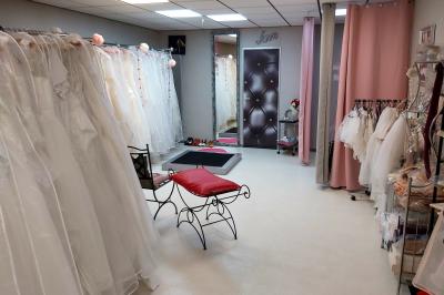 Miniature Palma & Princess #3 Robes élégantes sur mannequins et vêtements suspendus dans une pièce lumineuse avec rangements et cintres.