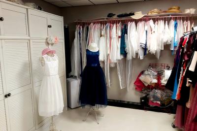 Miniature Palma & Princess #8 Robes élégantes sur mannequins et vêtements suspendus dans une pièce lumineuse avec rangements et cintres.