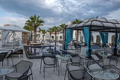 Des jeunes femmes en robes de soirée interagissent avec des résidents d'un établissement, dans une ambiance conviviale.