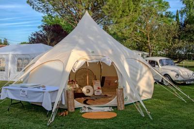 Des jeunes femmes en robes de soirée interagissent avec des résidents d'un établissement, dans une ambiance conviviale.