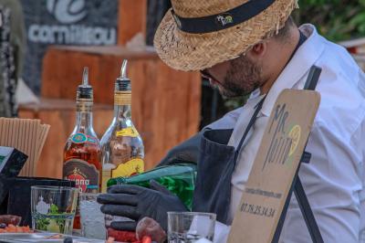 Des jeunes femmes en robes de soirée interagissent avec des résidents d'un établissement, dans une ambiance conviviale.