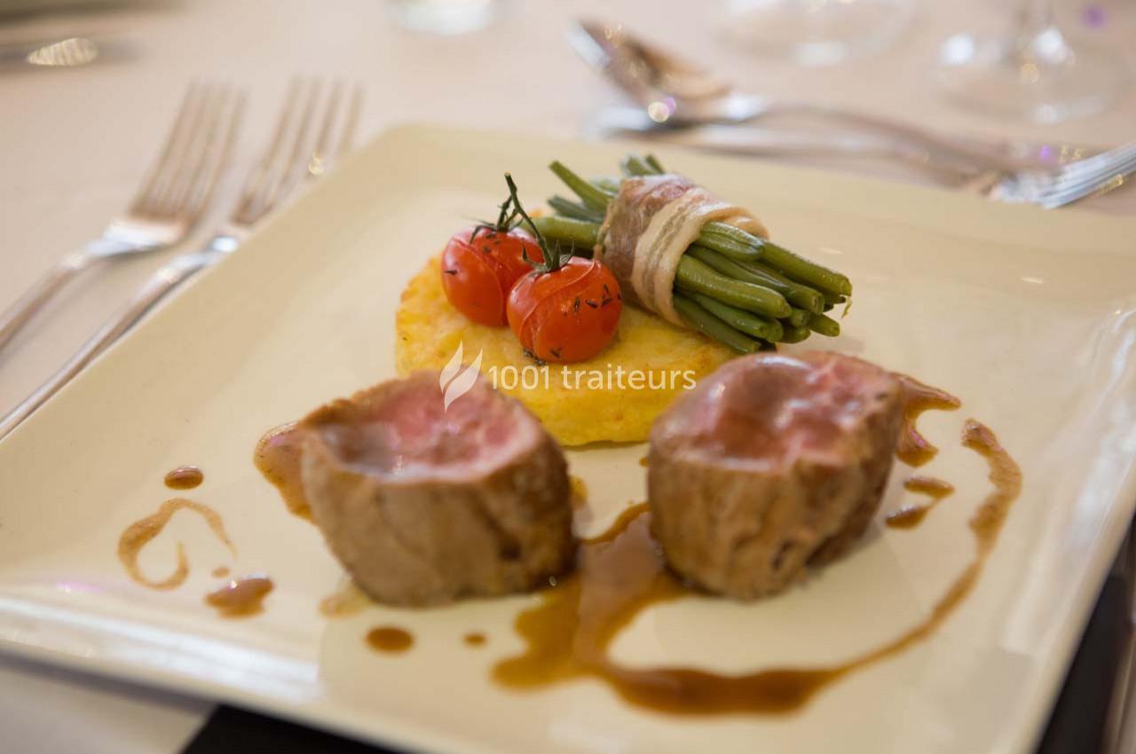 Assiette de viande rosée avec haricots verts enroulés de lard, tomates cerises et galette de pommes de terre.