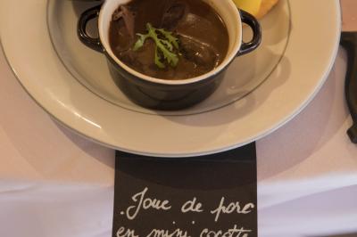 Assiette contenant une mousse verte garnie de persil, accompagnée de tomates rôties et de points de sauce balsamique.