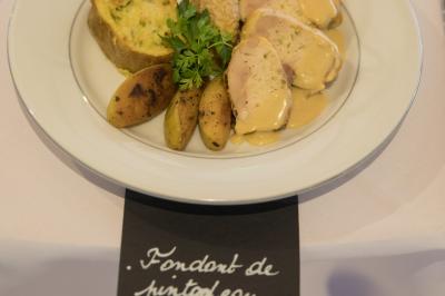 Assiette contenant une mousse verte garnie de persil, accompagnée de tomates rôties et de points de sauce balsamique.