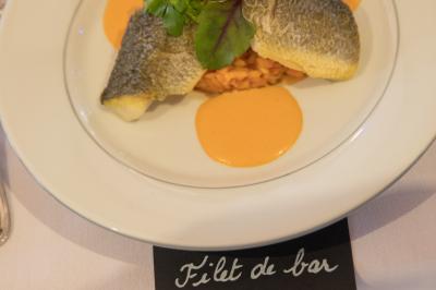 Assiette contenant une mousse verte garnie de persil, accompagnée de tomates rôties et de points de sauce balsamique.