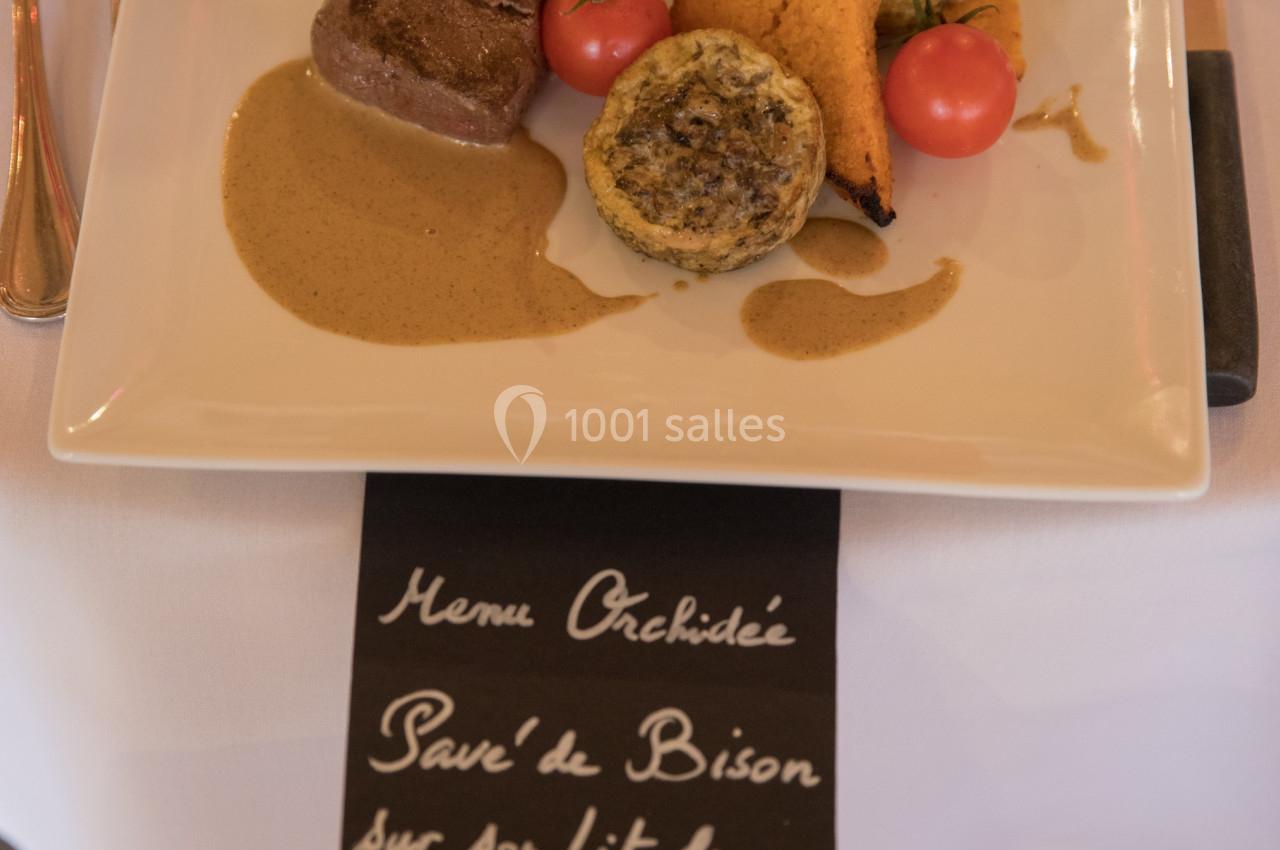 Assiette de pavé de bison avec sauce forestière, accompagnée de légumes et d'une écriture manuscrite en dessous.
