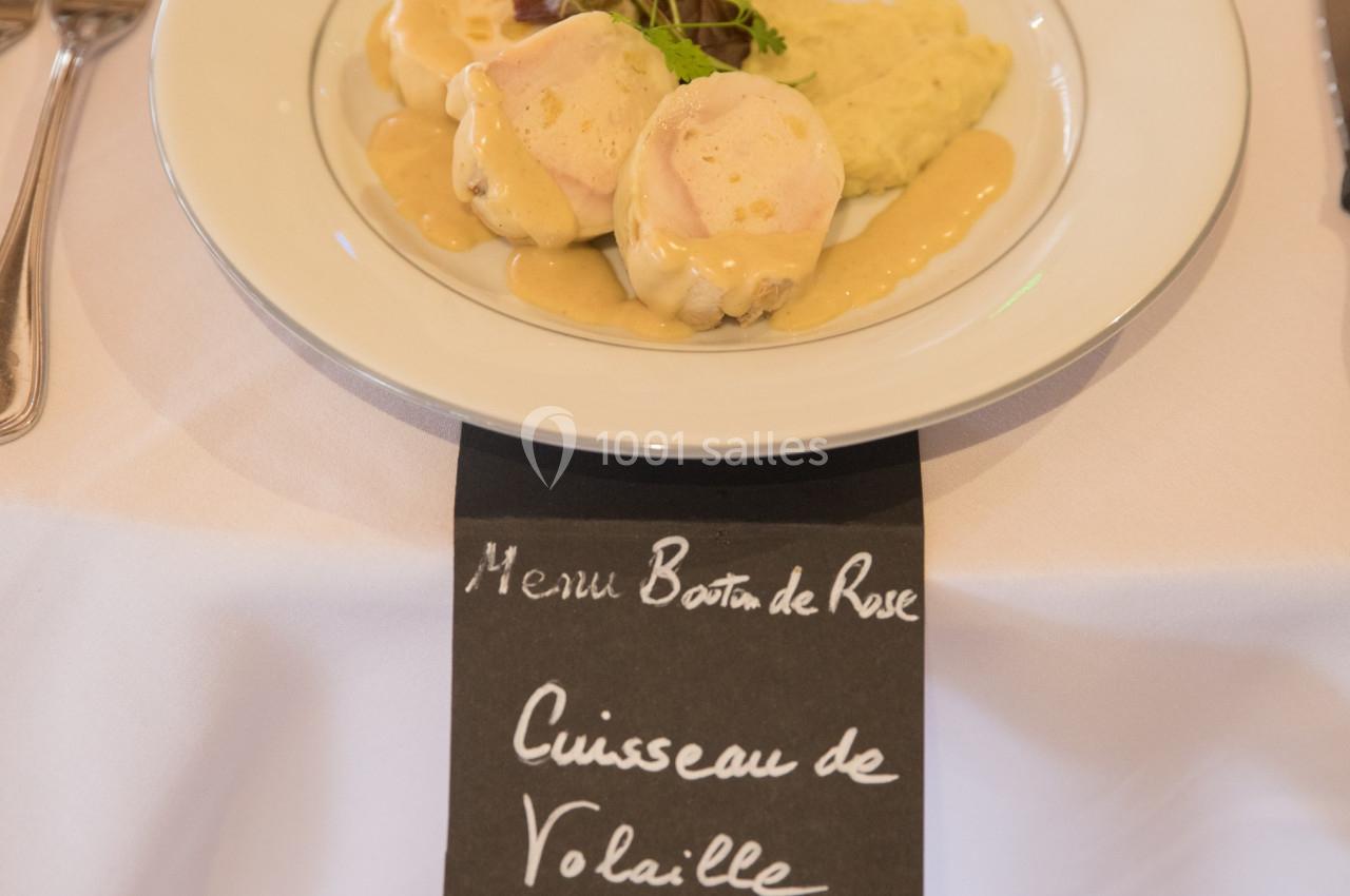 Assiette de cuisses de volaille avec sauce à l'abricotine, accompagnée de garnitures, sur une table dressée.
