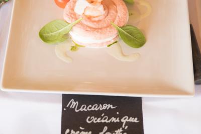 Assiette contenant une mousse verte garnie de persil, accompagnée de tomates rôties et de points de sauce balsamique.