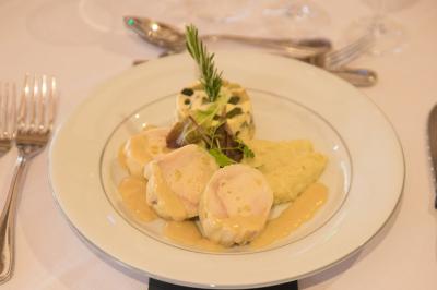 Assiette contenant une mousse verte garnie de persil, accompagnée de tomates rôties et de points de sauce balsamique.
