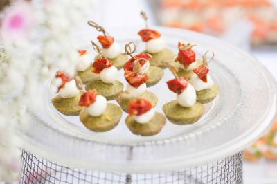 Assiette contenant une mousse verte garnie de persil, accompagnée de tomates rôties et de points de sauce balsamique.