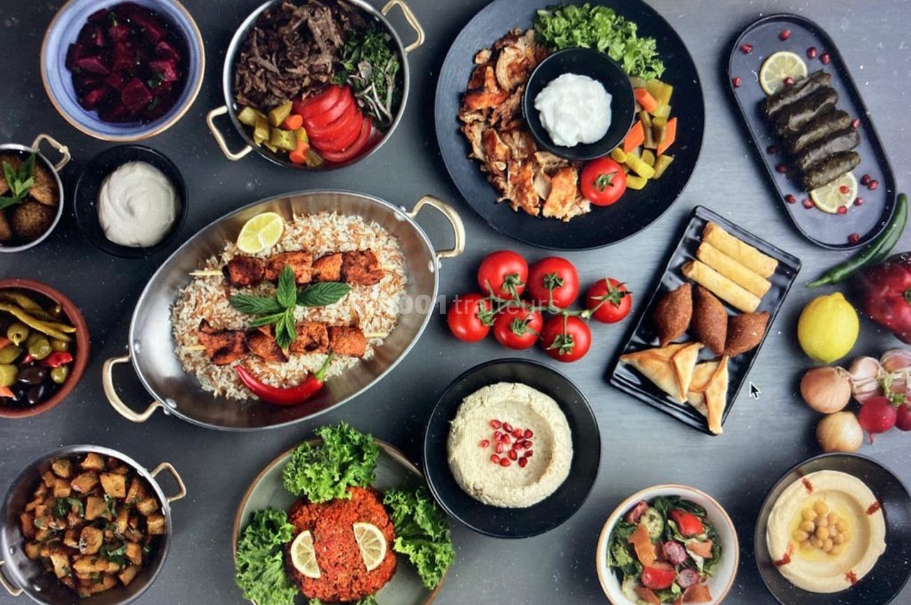 Assortiment de plats méditerranéens variés, incluant viandes grillées, mezzés, légumes et accompagnements.