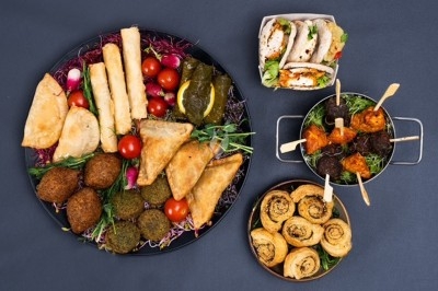 Miniature Traiteur Saint-Denis (Seine-Saint-Denis) - Leon Catering Libanais  #2 Assiette de wraps garnis autour d'un bol de sauce blanche, accompagnée de légumes marinés et de tranches de tomate.