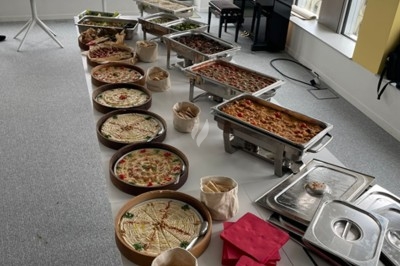 Miniature Traiteur Saint-Denis (Seine-Saint-Denis) - Leon Catering Libanais  #3 Assiette de wraps garnis autour d'un bol de sauce blanche, accompagnée de légumes marinés et de tranches de tomate.