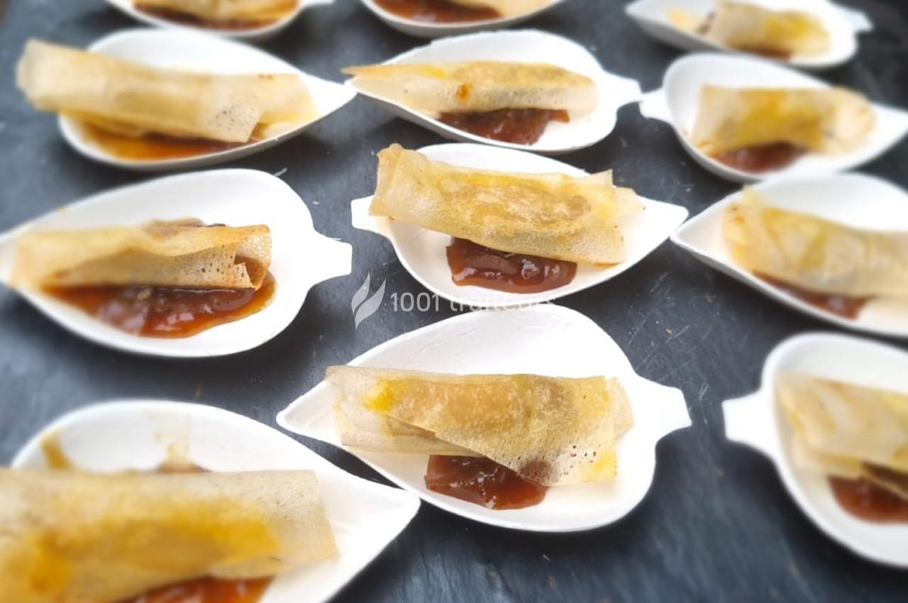 Assortiment de croustillants dorés servis sur des coupelles avec une sauce brune en fond.