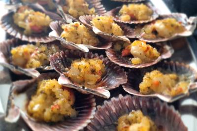 Miniature Traiteur Savigny-le-Temple (Seine-et-Marne) - Nos Tendances Traiteur #13 Huîtres gratinées garnies de fromage et épices, présentées sur un plateau en bois, avec légumes en arrière-plan.