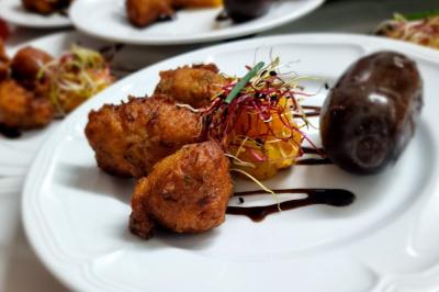 Miniature Traiteur Savigny-le-Temple (Seine-et-Marne) - Nos Tendances Traiteur #19 Huîtres gratinées garnies de fromage et épices, présentées sur un plateau en bois, avec légumes en arrière-plan.