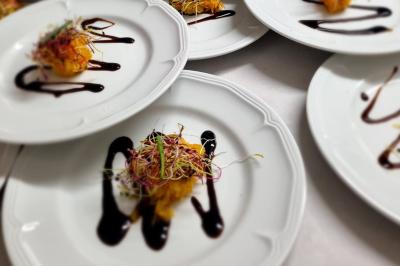 Miniature Traiteur Savigny-le-Temple (Seine-et-Marne) - Nos Tendances Traiteur #20 Huîtres gratinées garnies de fromage et épices, présentées sur un plateau en bois, avec légumes en arrière-plan.