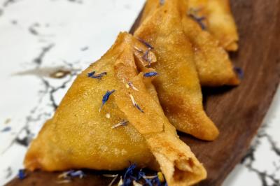 Miniature Traiteur Savigny-le-Temple (Seine-et-Marne) - Nos Tendances Traiteur #35 Huîtres gratinées garnies de fromage et épices, présentées sur un plateau en bois, avec légumes en arrière-plan.