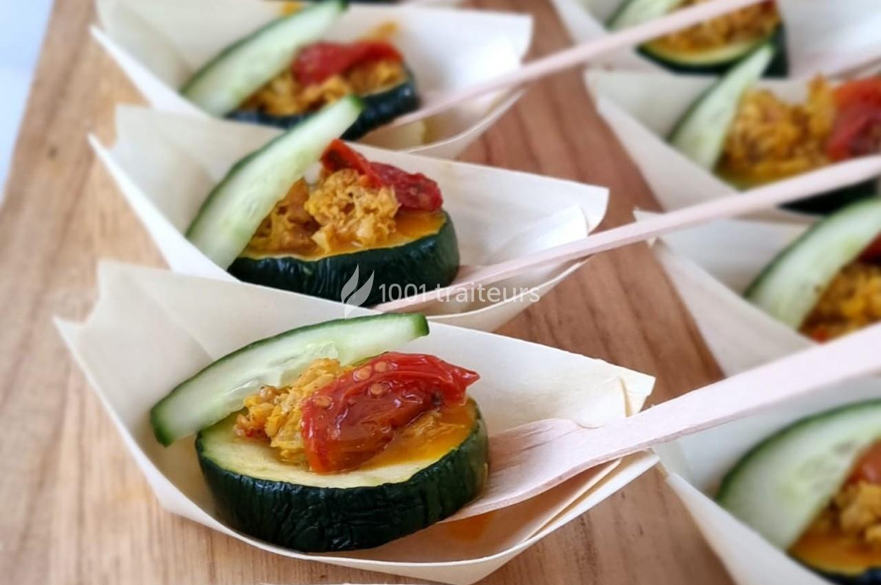 Tranches de courgette garnies de légumes et servies dans des coupelles en bois avec des mini-fourchettes.