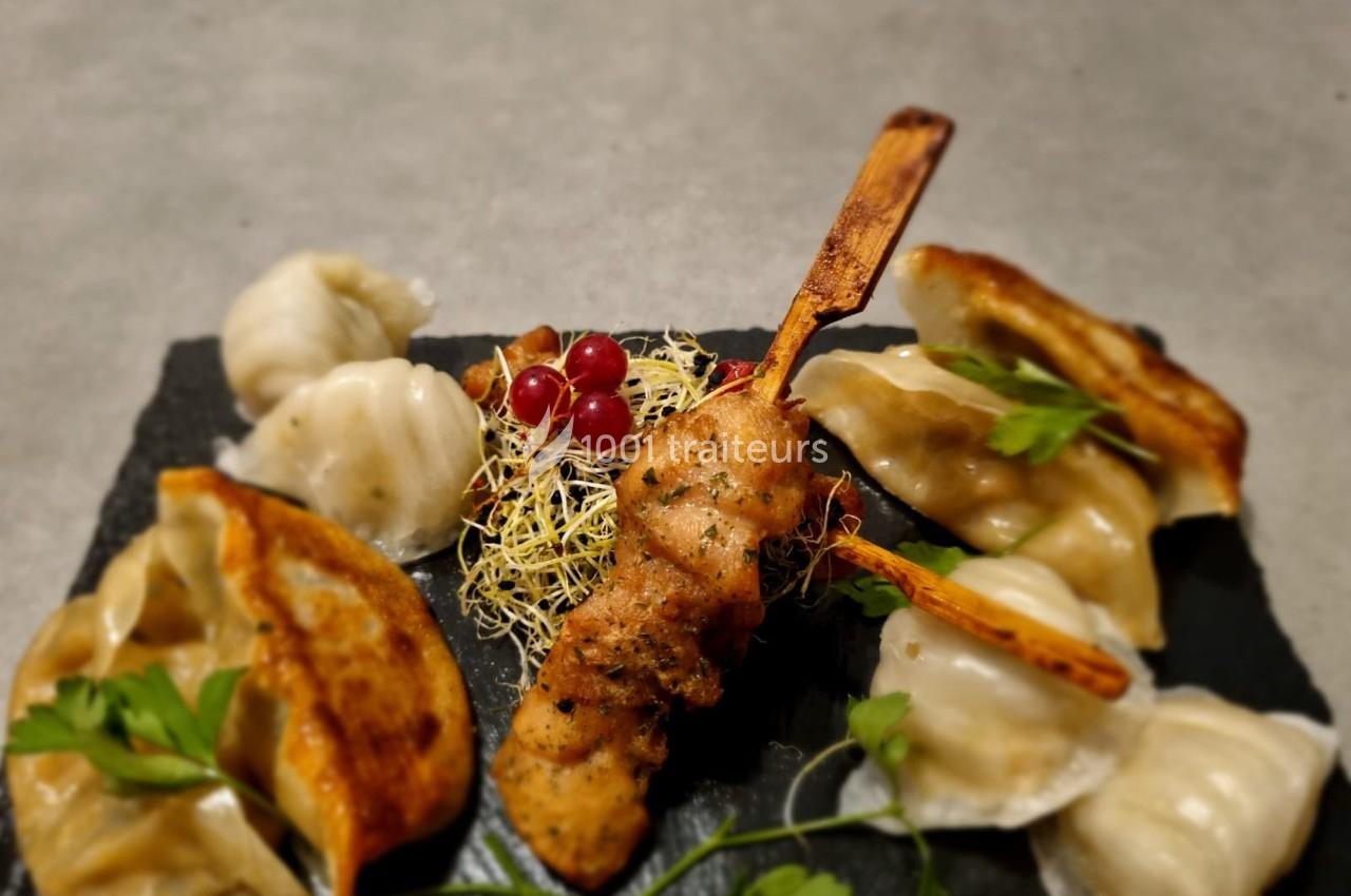 Assiette composée de raviolis vapeur et grillés, brochette de poulet, germes de luzerne, groseilles et persil.