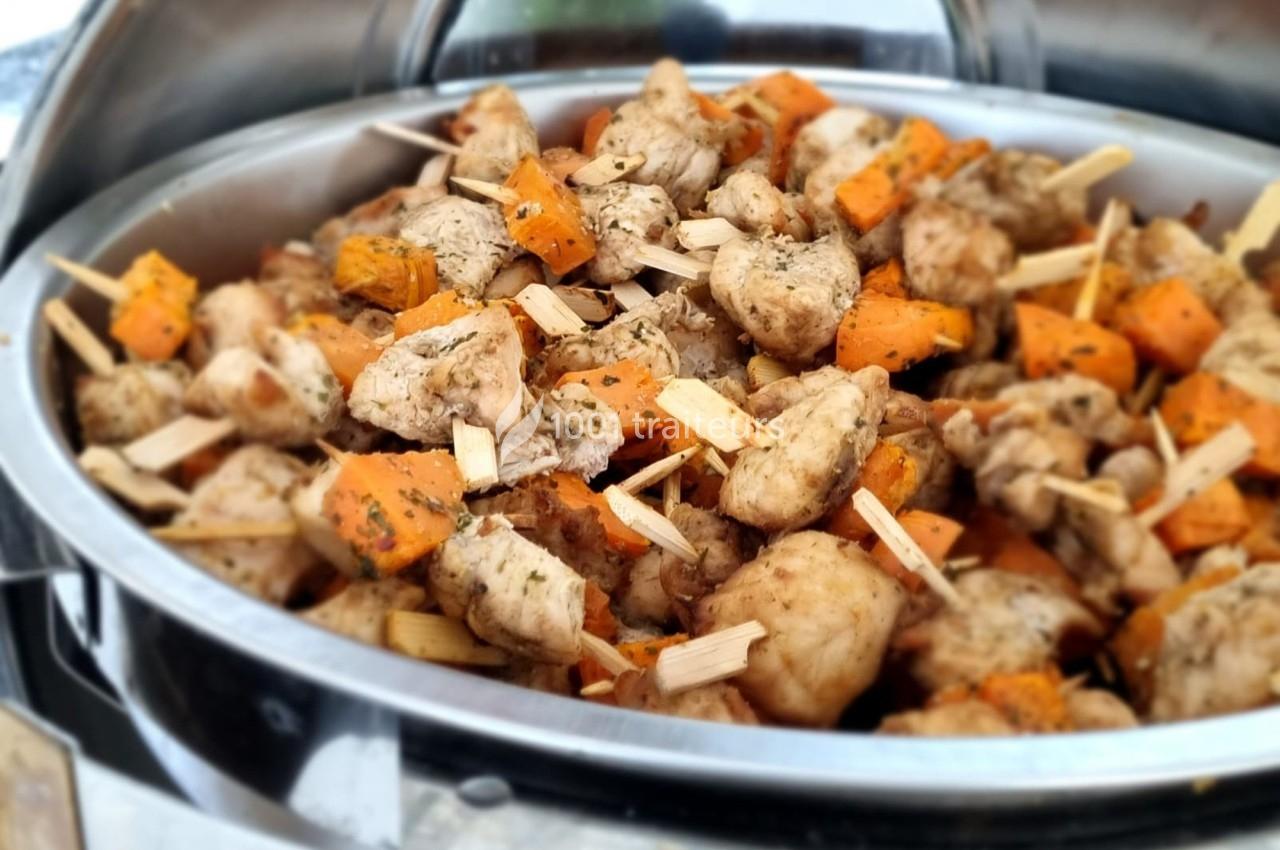 Brochettes de poulet et patates douces assaisonnées, présentées dans un plat en métal pour un service buffet.