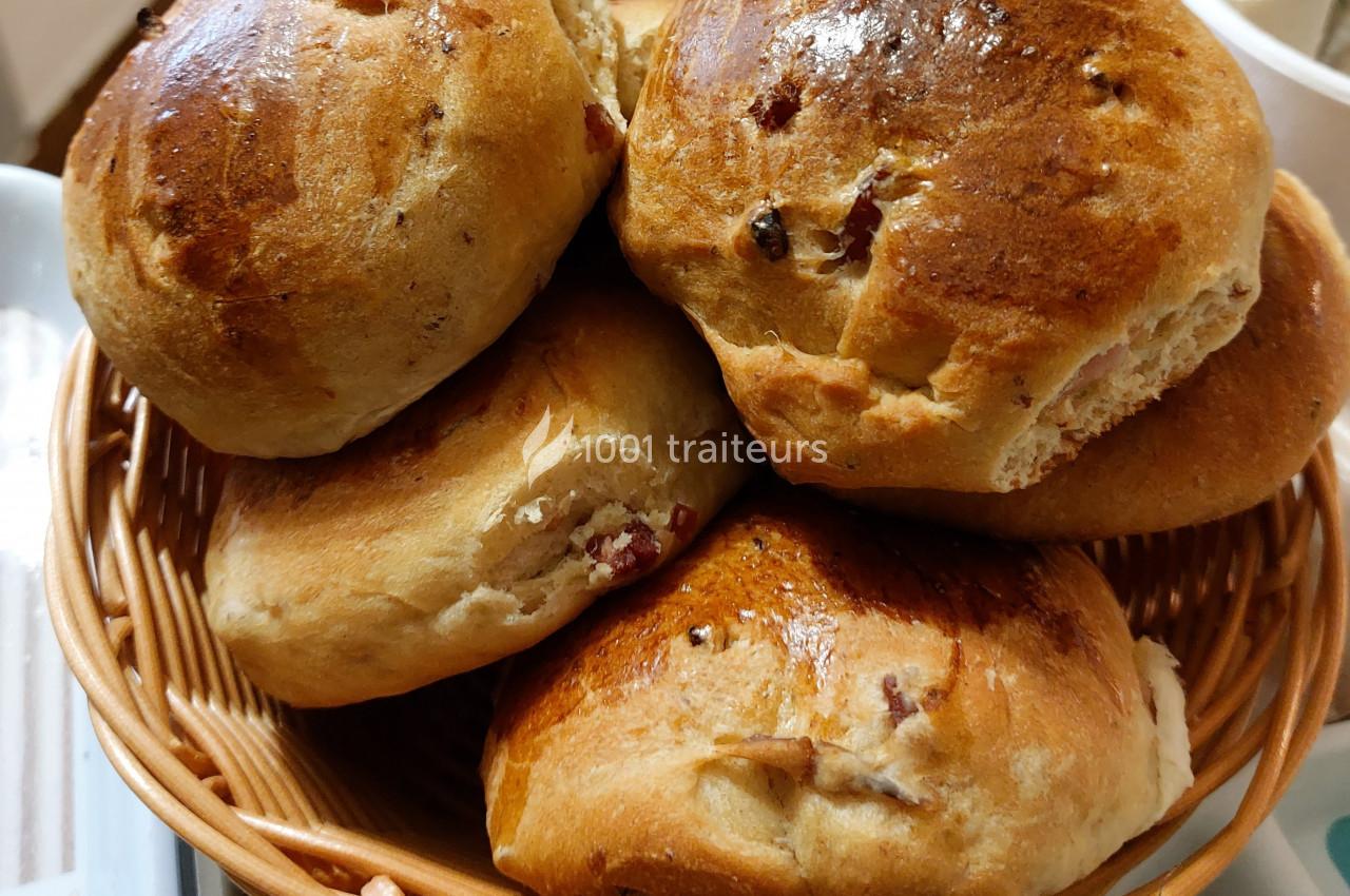 Pains briochés dorés avec des inclusions de fruits secs, disposés dans un panier en osier.