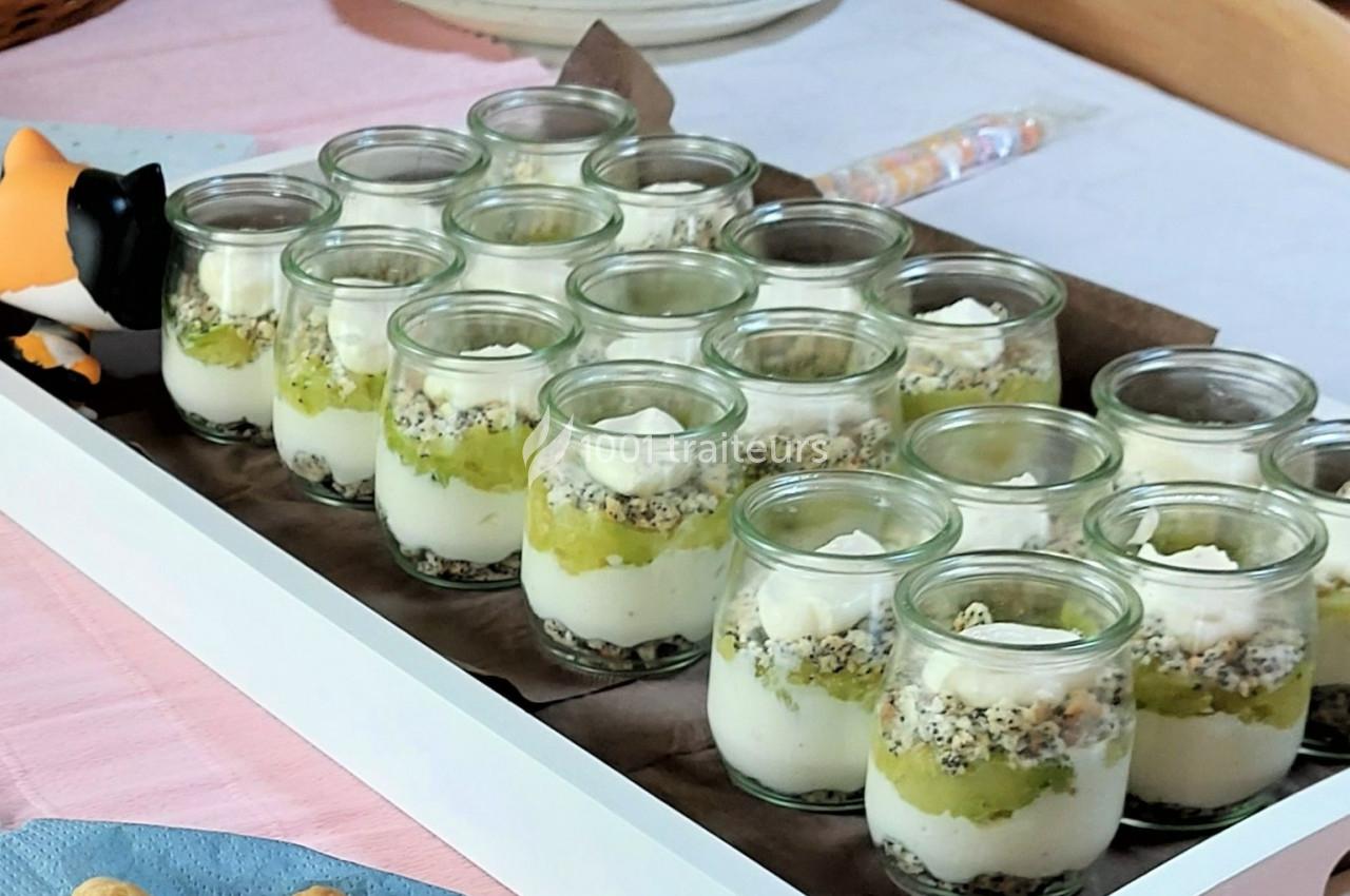 Desserts en verrines avec couches de yaourt, compote verte et granola, présentés sur un plateau blanc.