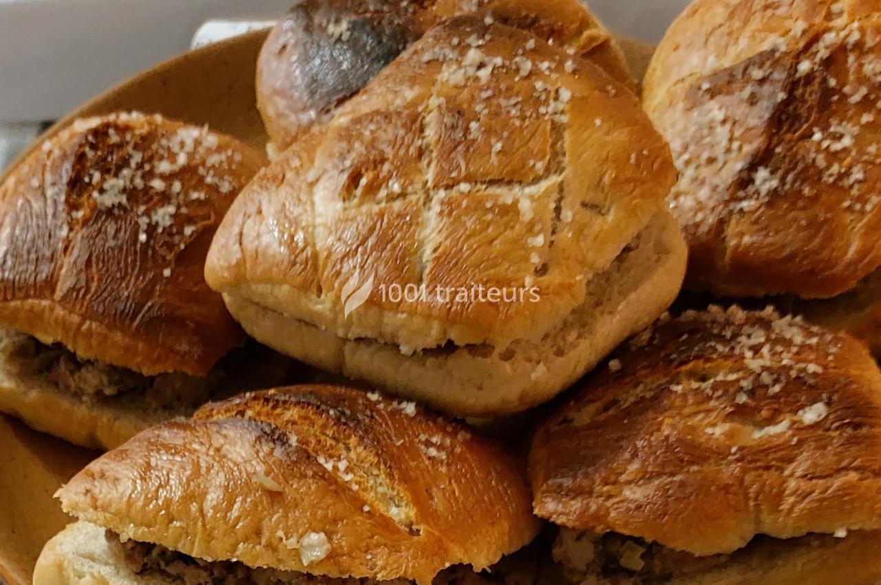 Petits pains dorés garnis de viande hachée, disposés sur une assiette marron.
