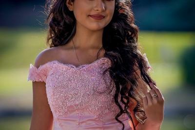 Un couple en tenue de mariage traditionnelle, l'homme en sherwani blanc et la femme en robe brodée rouge.
