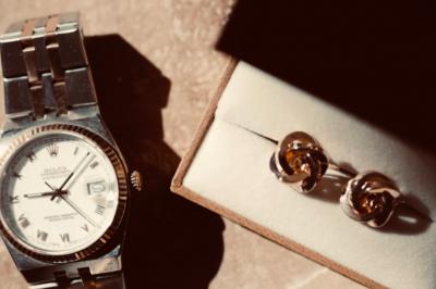 Un couple en tenue de mariage traditionnelle, l'homme en sherwani blanc et la femme en robe brodée rouge.