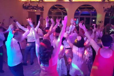 Un homme en costume est porté par une foule festive sous des guirlandes lumineuses, en extérieur de nuit.