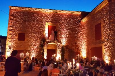 Un homme en costume est porté par une foule festive sous des guirlandes lumineuses, en extérieur de nuit.