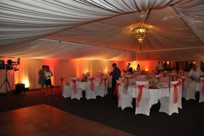 Un homme en costume est porté par une foule festive sous des guirlandes lumineuses, en extérieur de nuit.