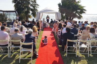 Un homme en costume est porté par une foule festive sous des guirlandes lumineuses, en extérieur de nuit.