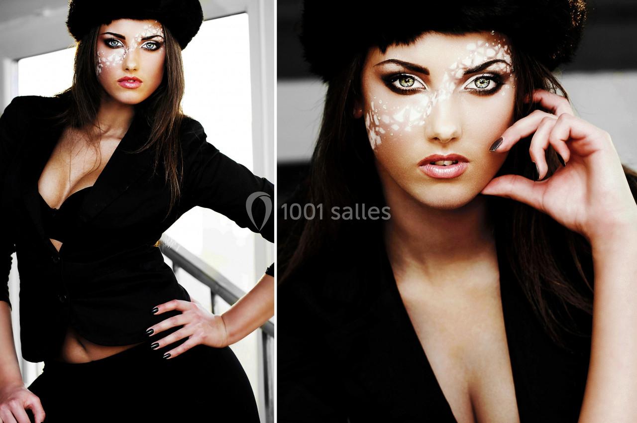 Femme en tenue noire avec un maquillage artistique blanc sur le visage, posant dans un environnement lumineux.