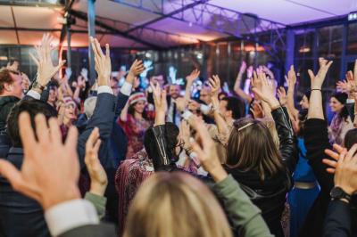 Groupe de personnes rassemblées dans un parc verdoyant lors d'un événement en plein air.