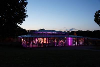 Groupe de personnes rassemblées dans un parc verdoyant lors d'un événement en plein air.