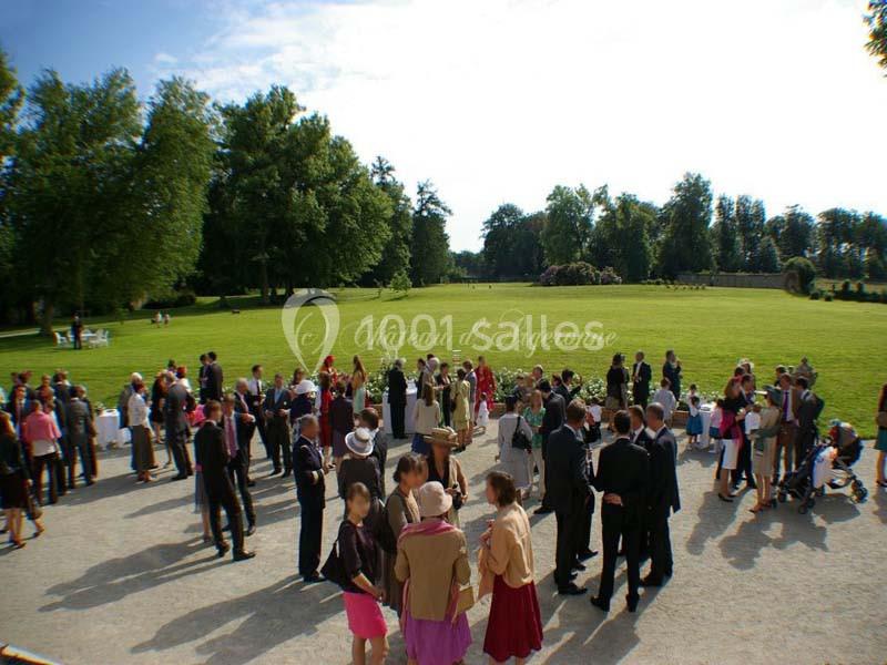 Groupe de personnes rassemblées dans un parc verdoyant lors d'un événement en plein air.