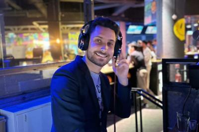 Miniature DJ La Queue-les-Yvelines (Yvelines) - DJ Braz #13 Main ajustant les réglages sur une table de mixage DJ illuminée par des lumières colorées.