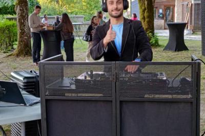 Miniature DJ La Queue-les-Yvelines (Yvelines) - DJ Braz #17 Main ajustant les réglages sur une table de mixage DJ illuminée par des lumières colorées.