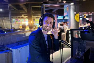 Miniature DJ La Queue-les-Yvelines (Yvelines) - DJ Braz #23 Main ajustant des réglages sur une table de mixage DJ lumineuse avec des écrans et des boutons colorés.