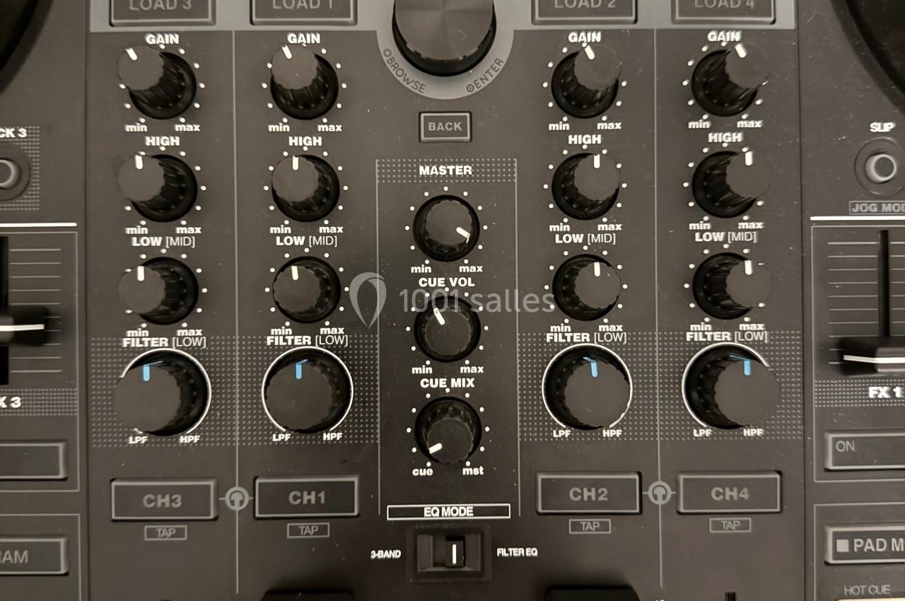 Table de mixage audio avec plusieurs boutons de réglage, curseurs et écrans intégrés pour le contrôle du son.