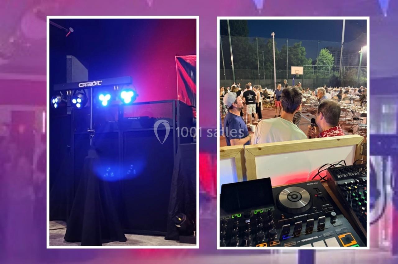 Installation de matériel de DJ avec éclairage coloré et scène extérieure animée lors d'un événement nocturne.