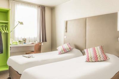 Buffet de viennoiseries et pains variés disposés sur un comptoir noir avec jus de fruits en arrière-plan.