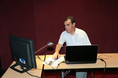 Un groupe de personnes pose devant une bannière, une femme au centre tient un diplôme.