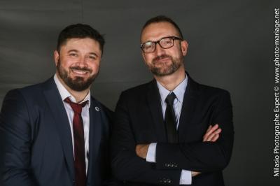 Un groupe de personnes pose devant une bannière, une femme au centre tient un diplôme.