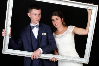 Un couple en tenue de mariage danse sur une place pavée devant un bâtiment historique.