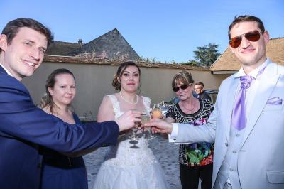 Un couple en tenue de mariage danse sur une place pavée devant un bâtiment historique.