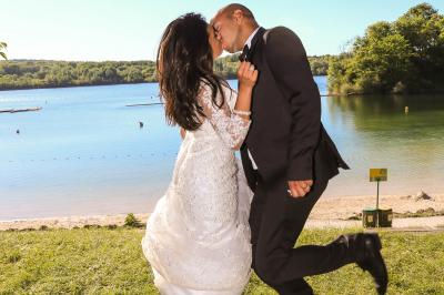 Un couple en tenue de mariage danse sur une place pavée devant un bâtiment historique.
