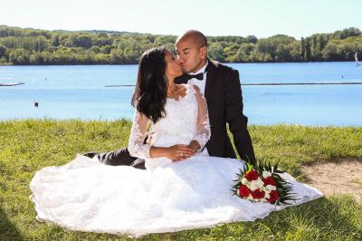 Un couple en tenue de mariage danse sur une place pavée devant un bâtiment historique.